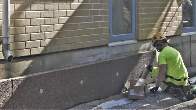 mies asentaa Isodrän levyjä sokkeliin