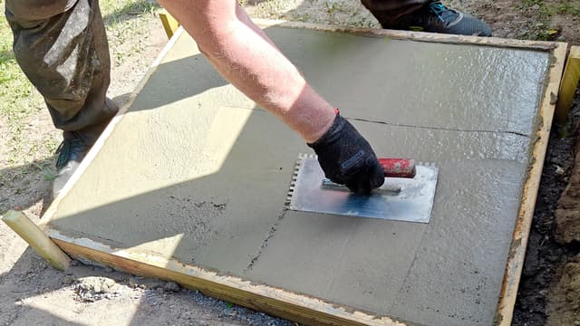 itse valettu betonilaatta kesällä ja sitä liipataan kuvassa